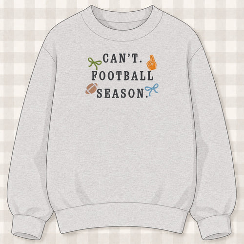 Ash gray crewneck sweatshirt with embroidered lettering reading can't football season with bows, a foam finger and a football